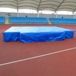 Modular high jump landing area with flame-retardant PVC cover and integrated wear sheet, designed for UKA club competitions.