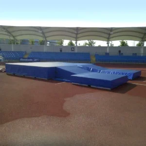 GMLM080 Blue club pole vault landing mat set up on a track facility, with castellated foam modules and reinforced PVC cover for optimal cushioning.