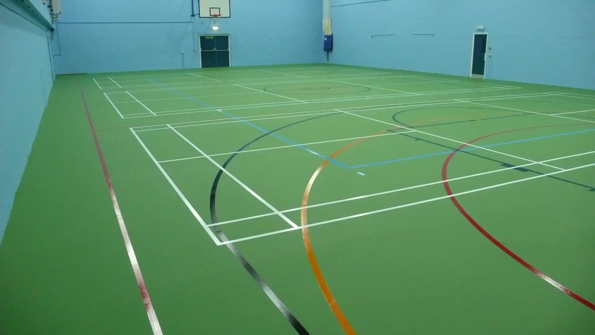 A green sports hall floor recently refurbished by gym-tech